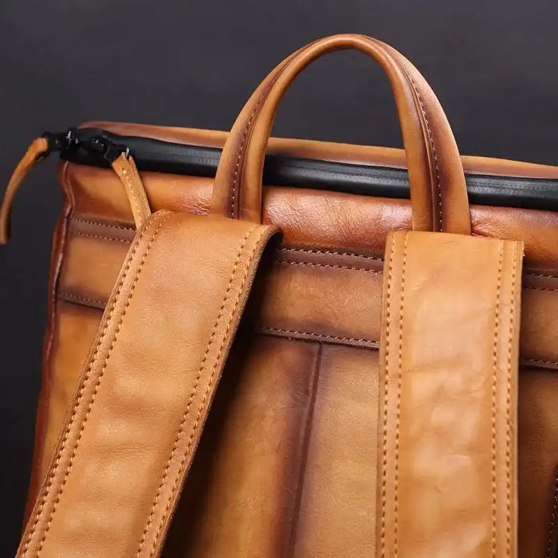 Detail view of the soft handle of a brown leather bag.