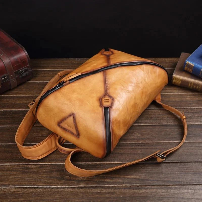 Stylish brown vintage leather backpack with unique design, soft handle and adjustable straps, top view.