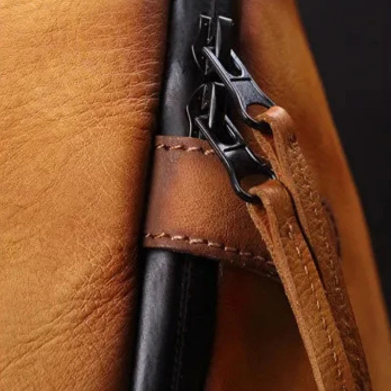 Detail view of the zippers of a brown leather bag.