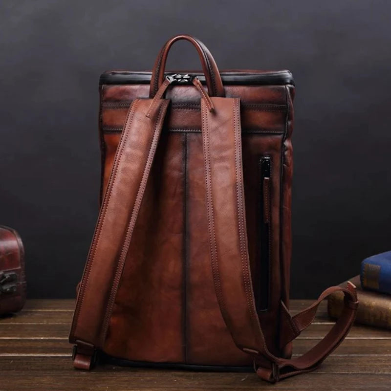 Stylish coffee brown vintage leather backpack with unique design, soft handle and adjustable straps, back view.