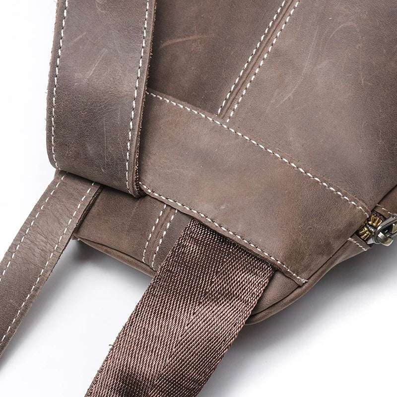 Close-up view of a vintage dark brown leather bag with detailed stitching - back view.