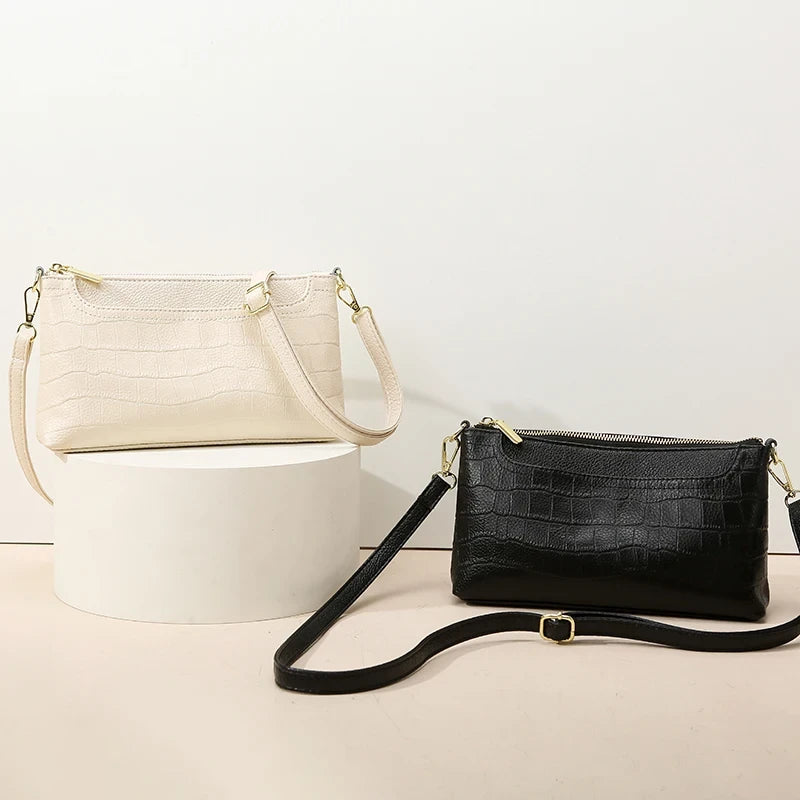Two elegant leather bags, one in beige and one in black, sdisplayed against a light surface.