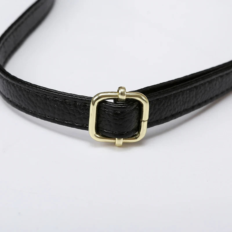 Black leather bag strap with gold buckle, ideal for creating elegant and casual looks.