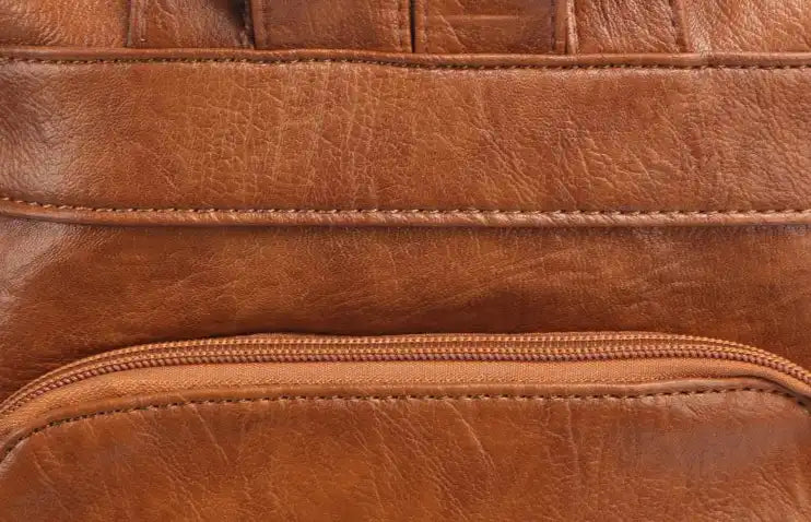 Close-up of a brown leather bag showcasing its texture and zipper.