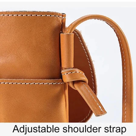 Detail of an adjustable strap on a brown leather bag, highlighting its functionality and style.