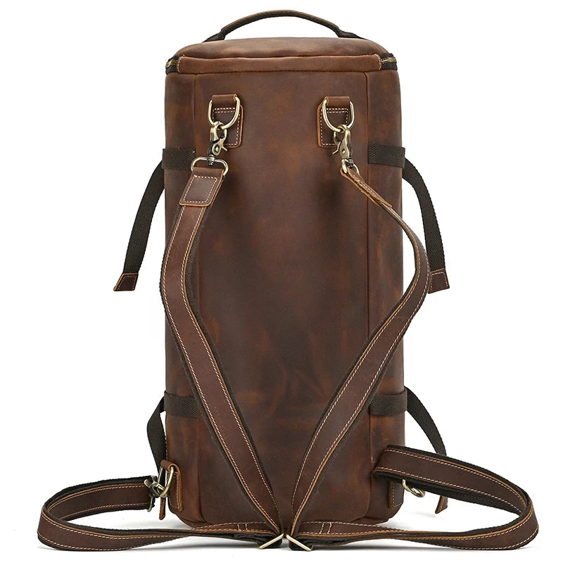 High quality brown leather duffle bag with adjustable straps and metal details, back view.