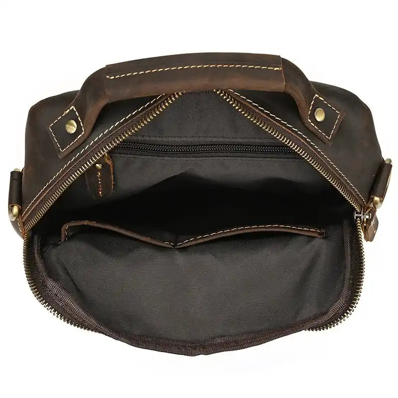 interior view of a leather bag, with a main compartment and a zippered pocket. Ideal for organizing belongings.