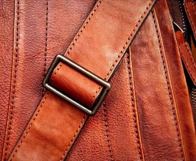 Detailed view of a brown leather strap with stitching.