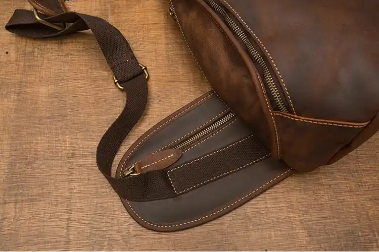 Detailed stitching of a brown leather sling bag highlighting craftsmanship.