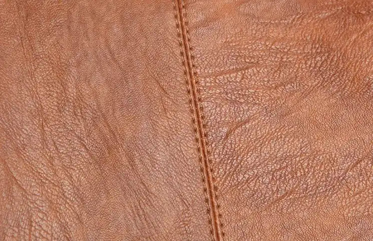 Close-up of a rich brown leather texture with visible grain and stitching.