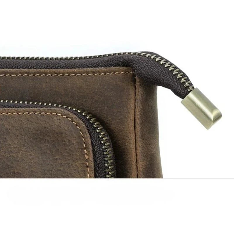 detailed view of a brown leather clutch showing the quality of its zippers.
