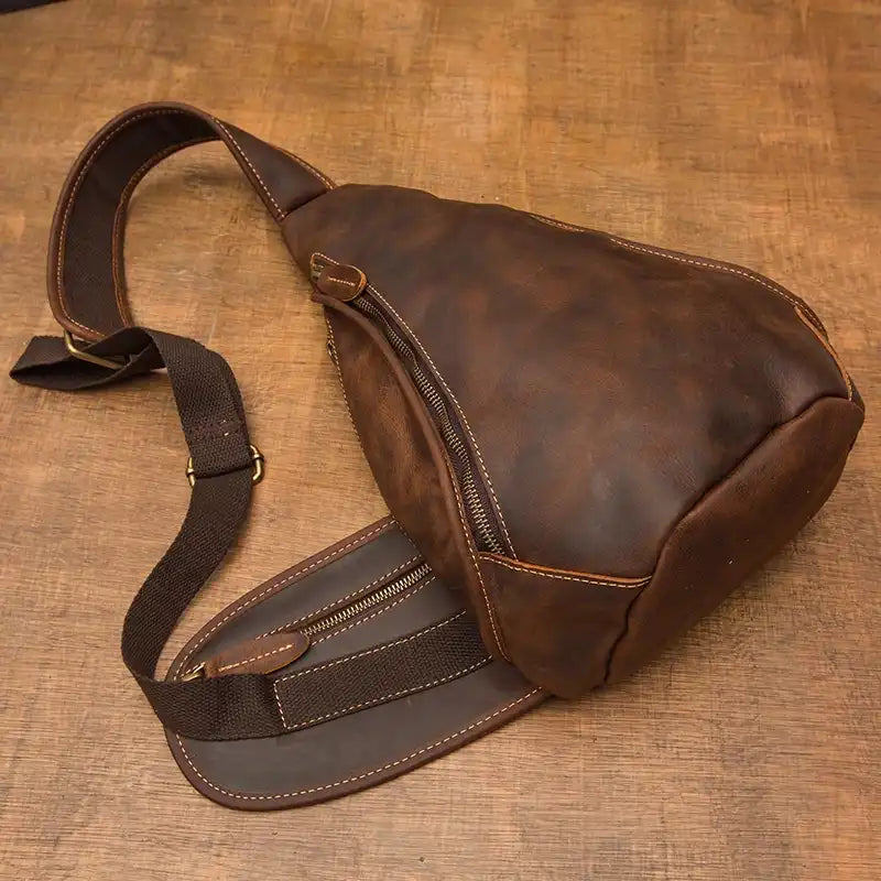 Durable leather sling bag featuring a secure zipper and comfortable strap.