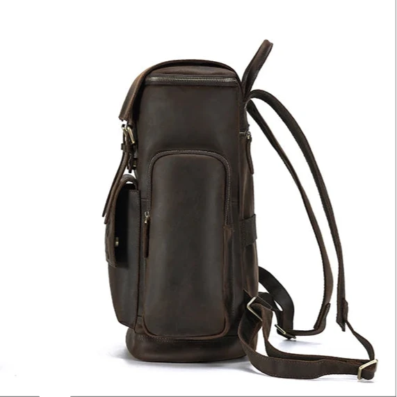 Side view of a vintage leather backpack showcasing its design, side pockets and straps.
