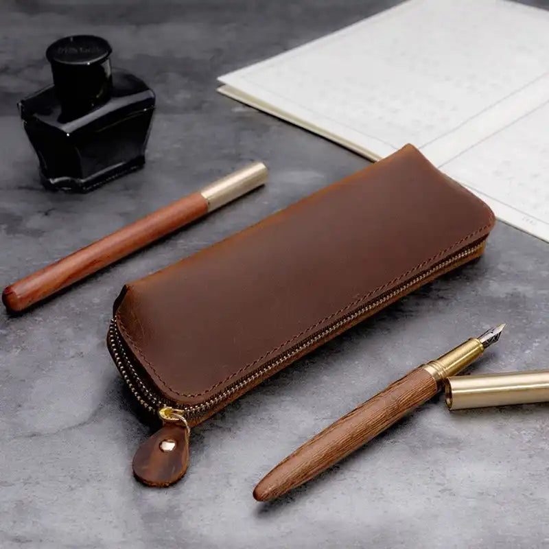 Elegant brown leather case in an office setting with pens.