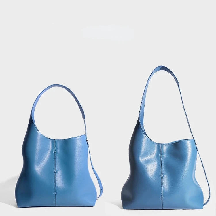 Two blue leather bags, highlighting the modern design and elegance, and strap positions, front view.