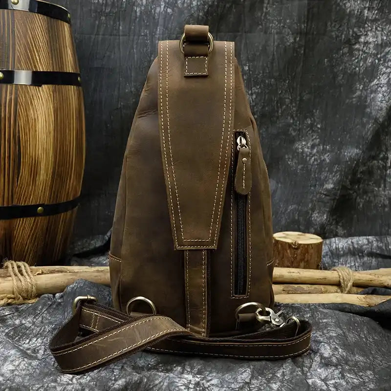 Stylish brown leather bag with an adjustable strap and back pocket, back view.
