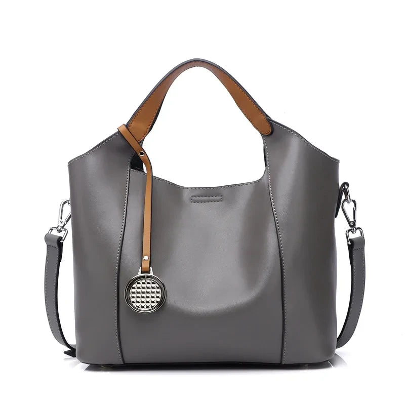Grey leather bag with soft detachable handles and elegant charm, front view - variant.