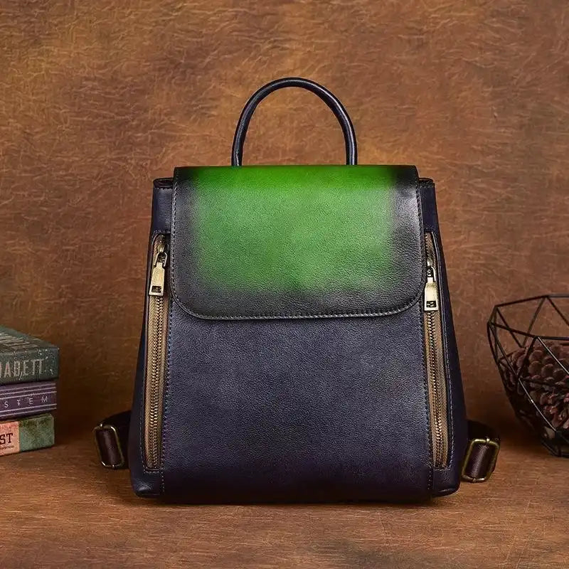 Leather backpack with an elegant design in green and blue colors, with zippers and handle, front view.