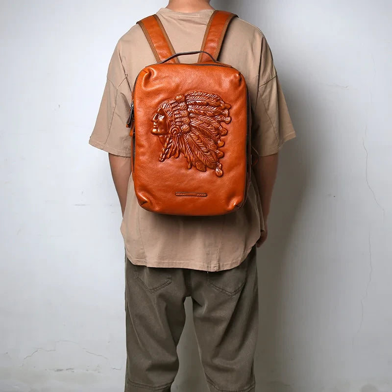 Man wearing on his back, a brown leather backpack with indigenous chief embossed print.