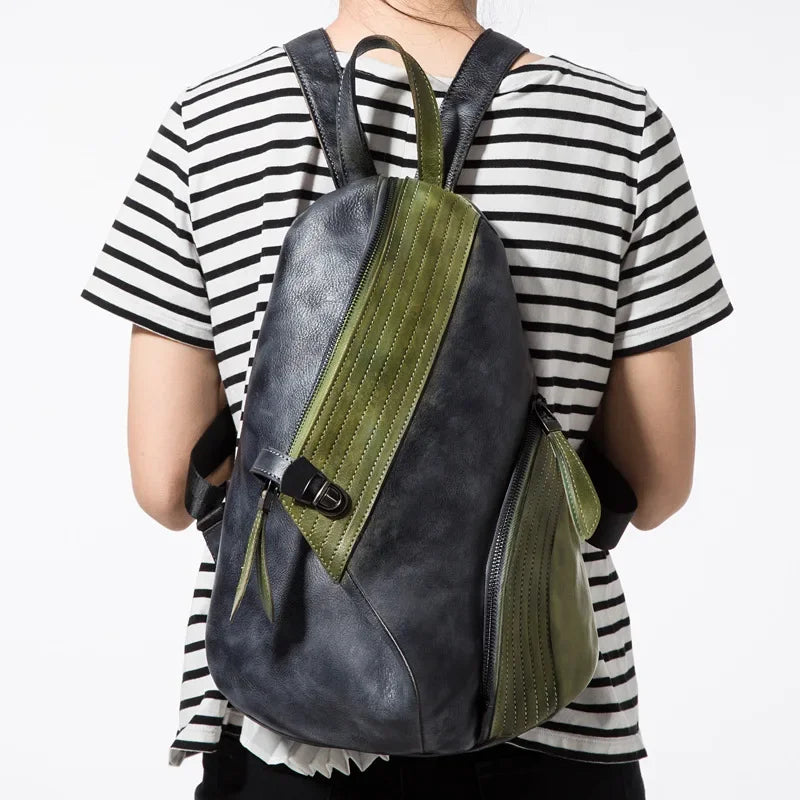 A stylish leather backpack with green and black design, worn by a person from the back.