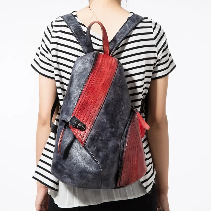 A stylish leather backpack with red and black design, worn by a person from the back.