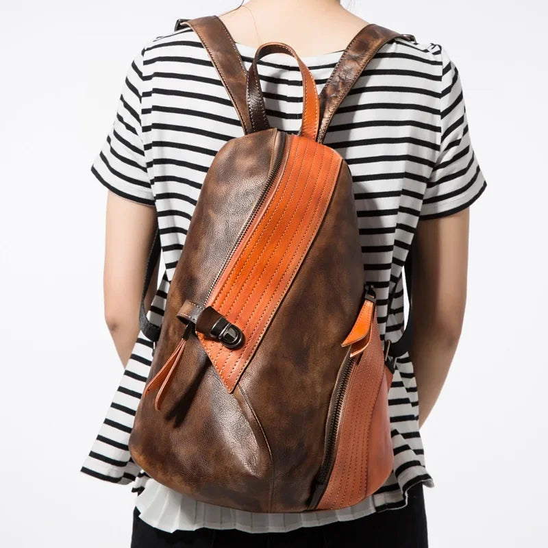A stylish leather backpack with yellow and brown design, worn by a person from the back.