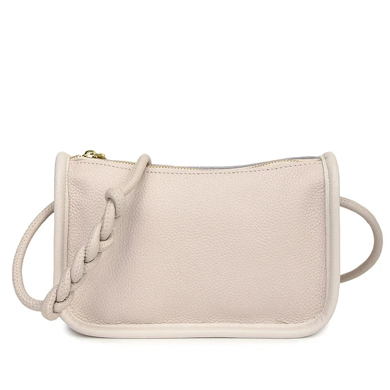 Stylish beige leather crossbody bag with braided strap - front view.