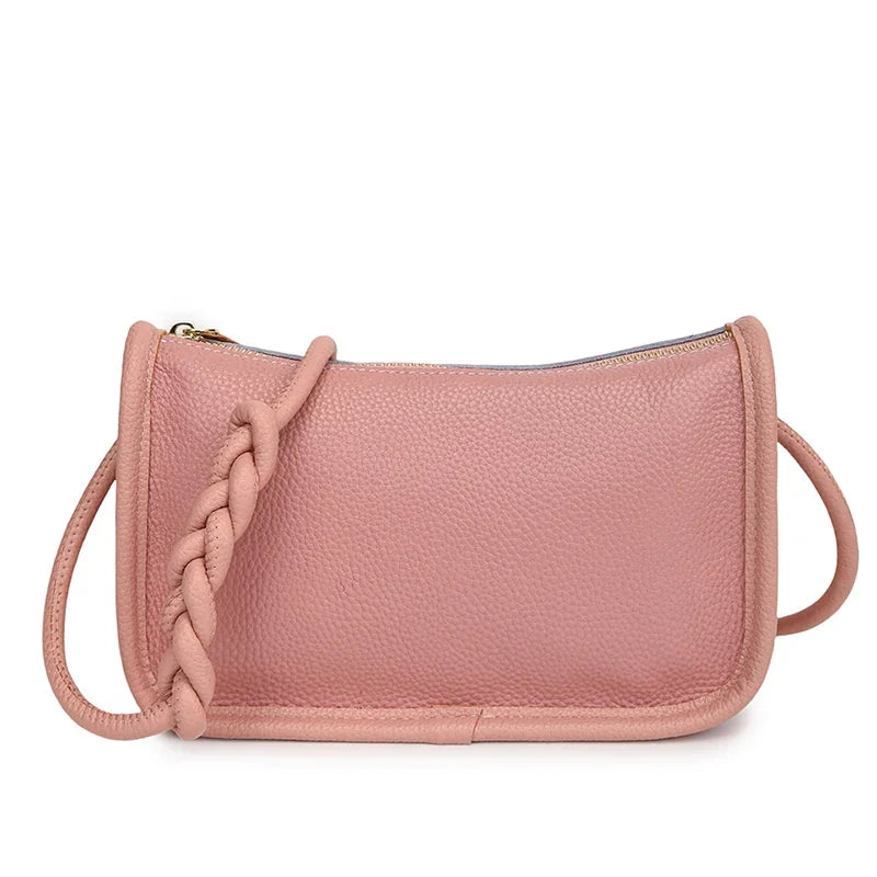 Stylish pink leather crossbody bag with braided strap - front view.