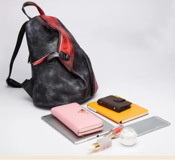 a stylish patchwork backpack with red and black accents and various accessories laid out beside it showcasing its capacity.
