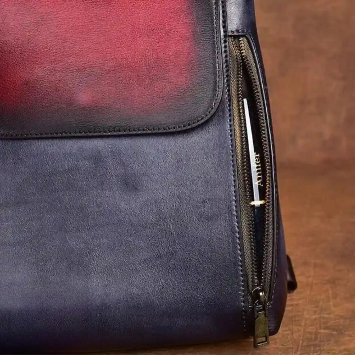 an elegant leather bag in blue and red colors, with zipper details, ideal for sophisticated fashion accessories.