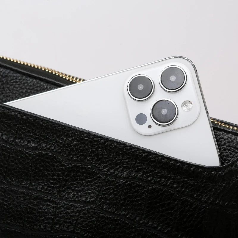 a smartphone, partially hidden in a black leather bag pocket.