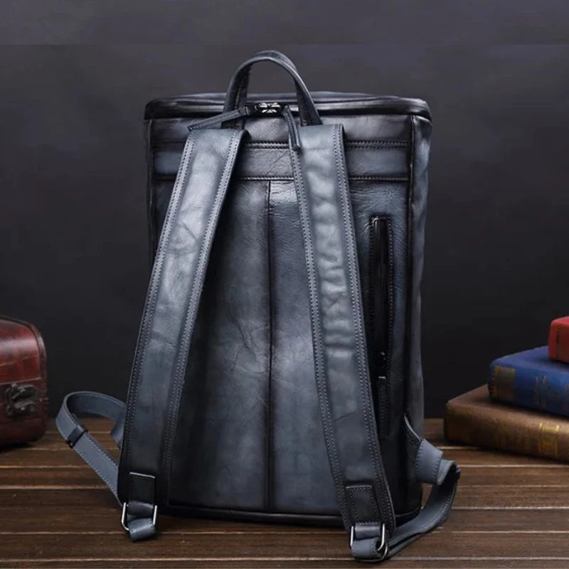 Stylish blue vintage men's leather backpack with unique design, soft handle and adjustable straps, back view.