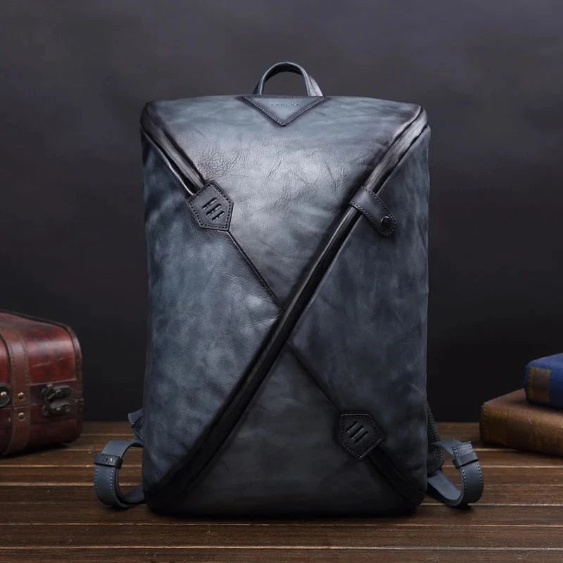 Stylish blue vintage leather backpack with unique design, soft handle and adjustable straps, front view.