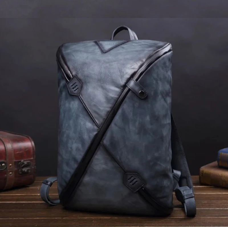 Stylish blue vintage men's leather backpack with unique design, soft handle and adjustable straps, front view.