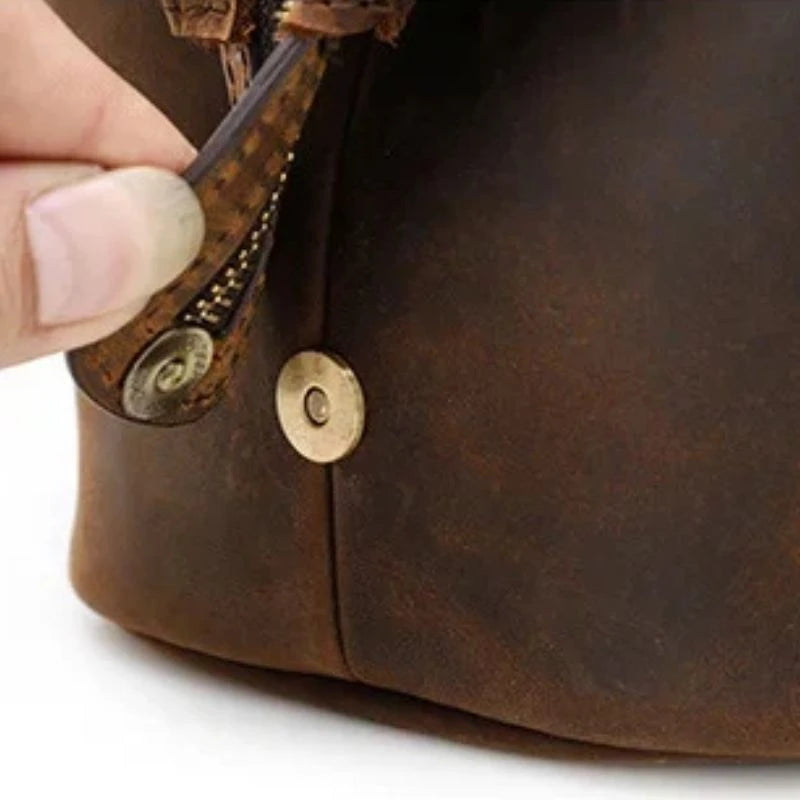 Detail of a brown leather bag with high quality magnetic closure button.
