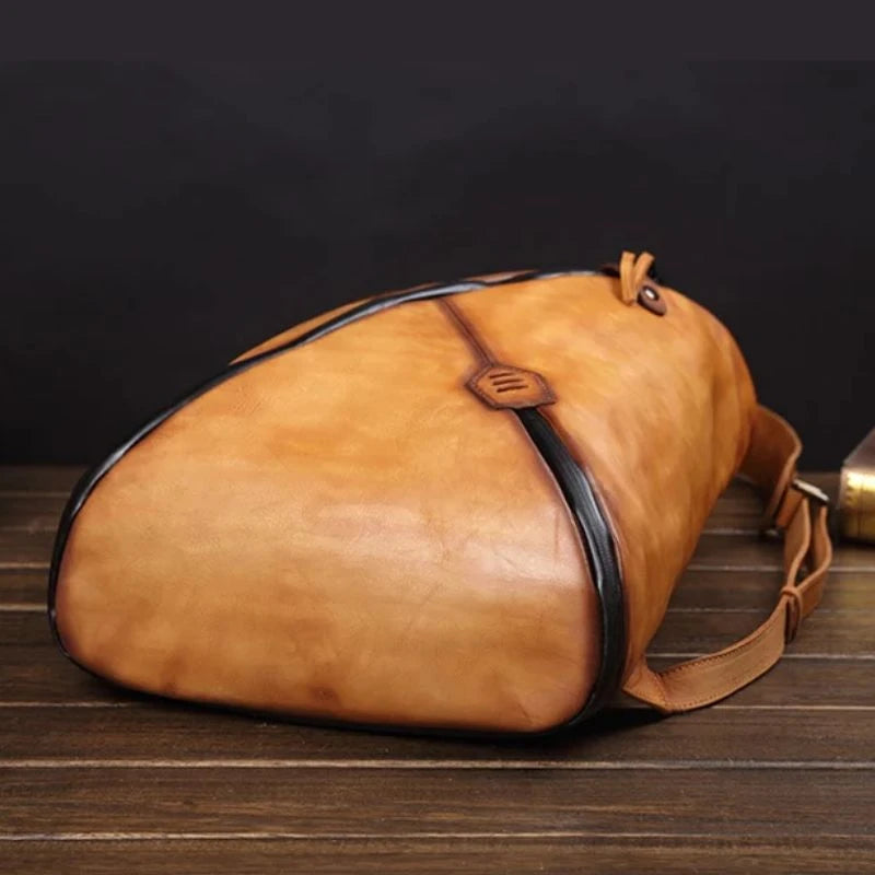 Stylish brown vintage leather backpack with unique design, soft handle and adjustable straps, bottom view.