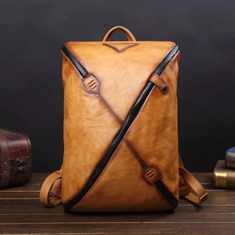 Stylish brown vintage leather backpack with unique design, soft handle and adjustable straps, front view.
