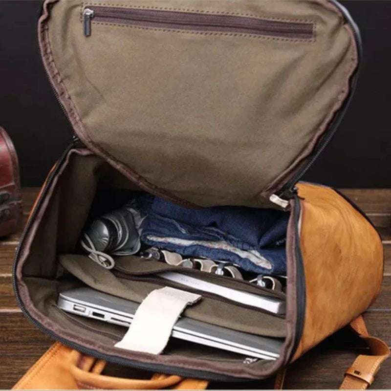 Interior view of stylish brown leather backpack showing compartments with laptop and other items.