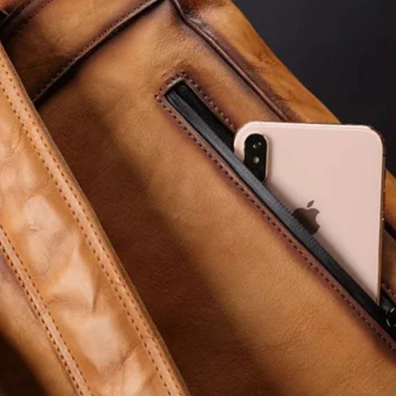 Detail view of phone pocket of a brown leather bag.