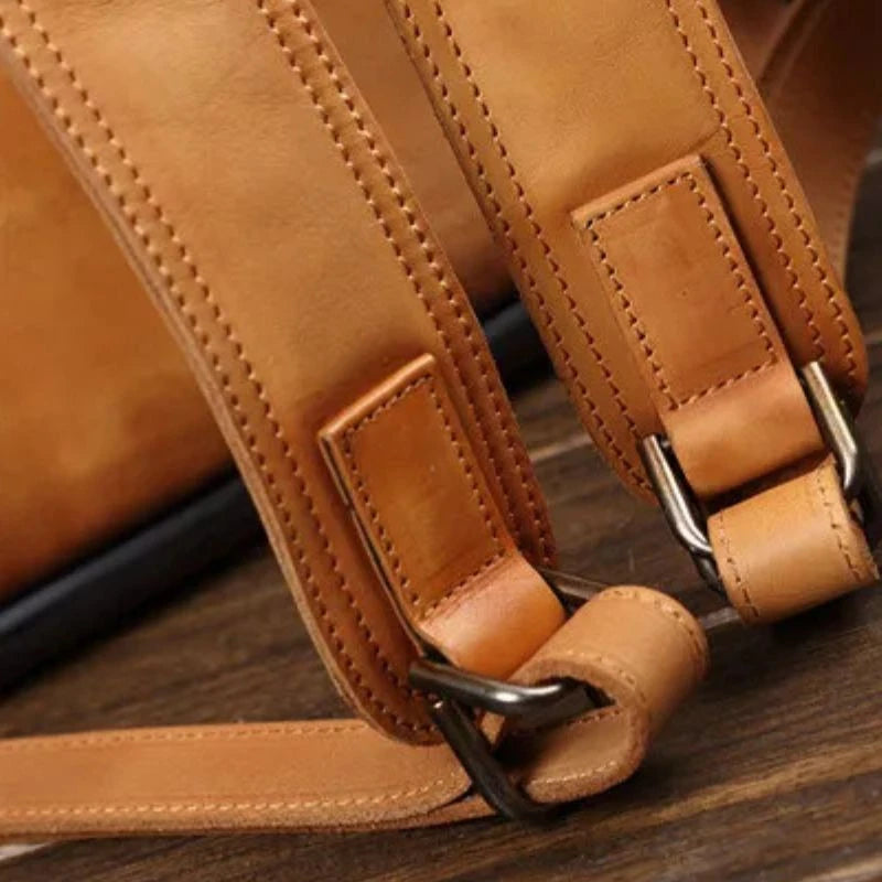 Detail view of the leather straps of a brown leather bag.