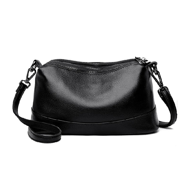 Black leather handbag with a strap on a white background, front view.