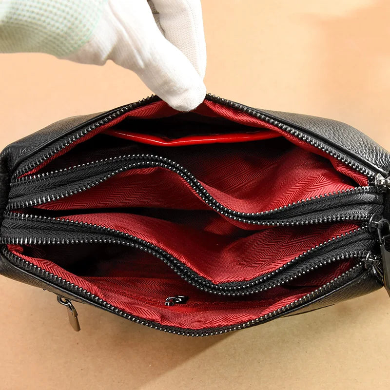 Organized internal layout close up view with red lining and three zippered compartments.
