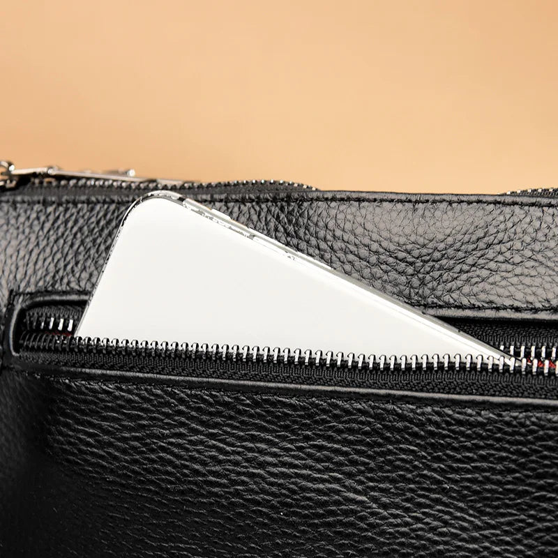 Chic Genuine Leather Shoulder Bag - Close-up of a black leather bag with a smartphone partially visible in the zipper pocket.