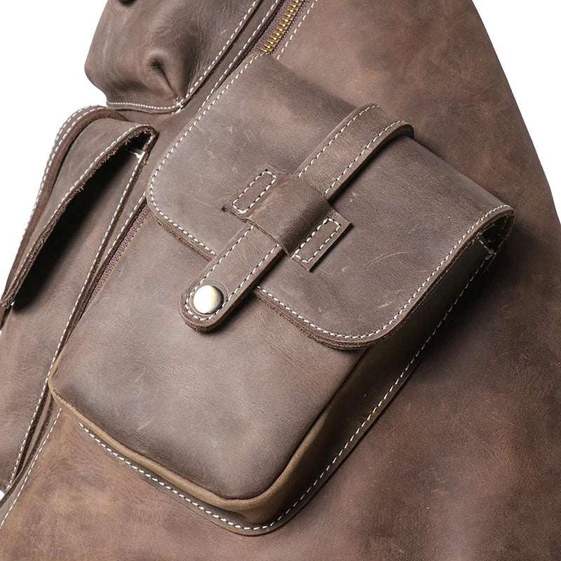 Close-up view of a vintage leather backpack with a front pocket and stitching details.