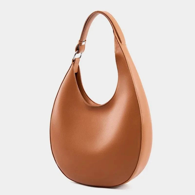 elegant brown leather bag, with a moon design and adjustable strap, front view