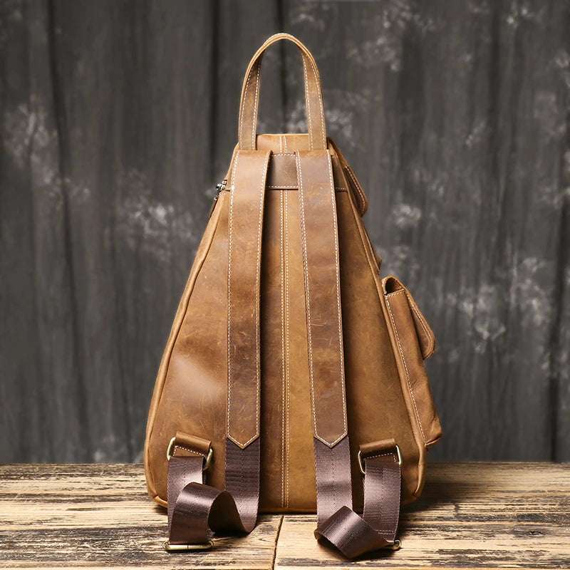 Close-up of a vintage leather backpack showcasing its straps and texture - back view.