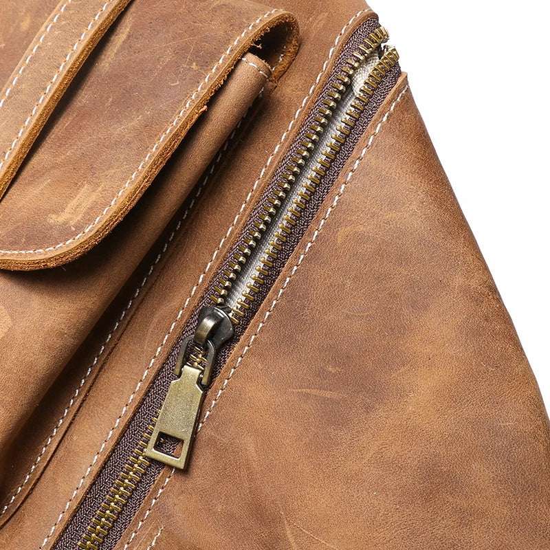 Close-up view highlights the quality zipper and weathered vintage finish of a leather backpack.