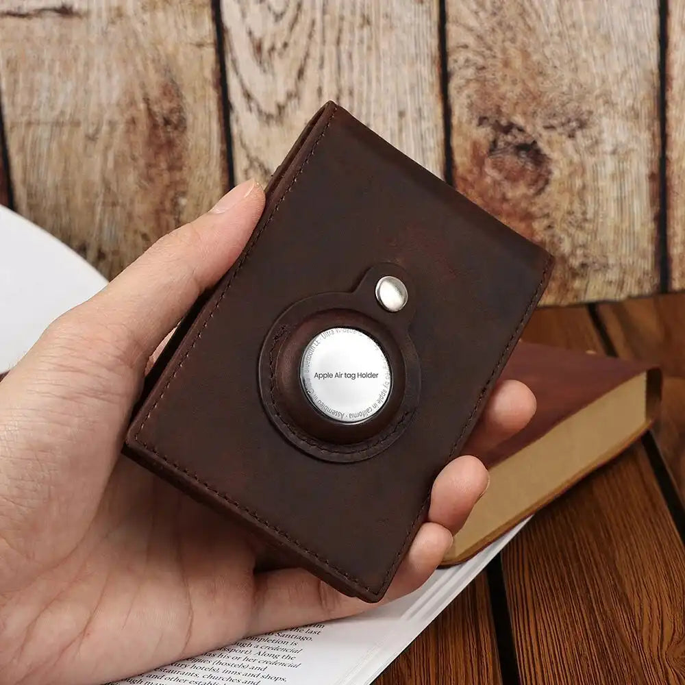 Close-up of a brown leather wallet with an AirTag holder in hand.