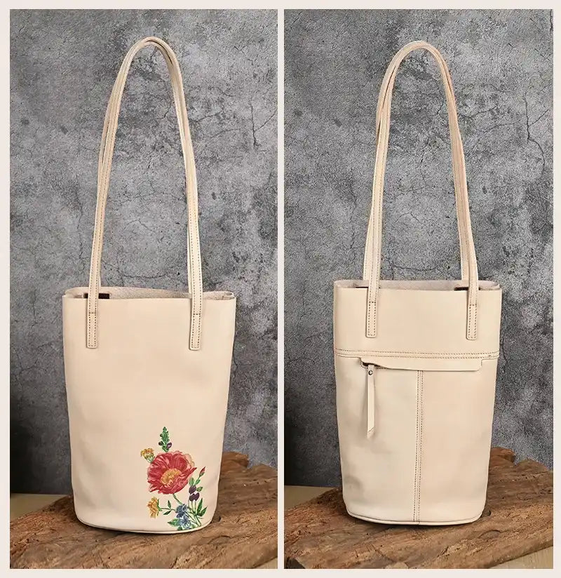 Beige leather tote bag with artistic design print, with leather handles and back zipped pocket, front and back views.