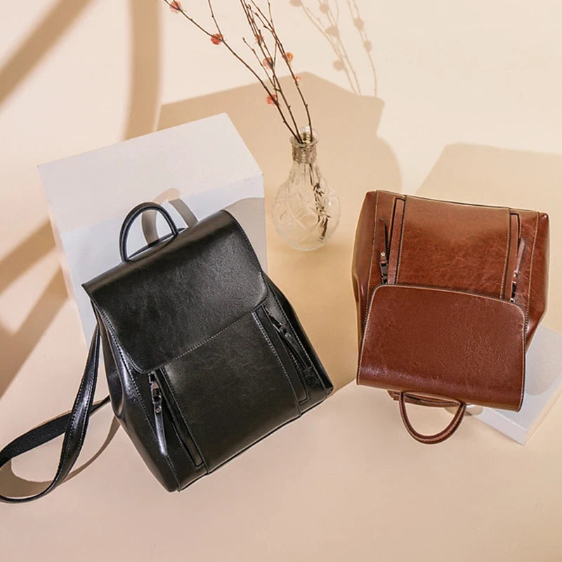 Two stylish leather backpacks in brown and black displayed on a light background.